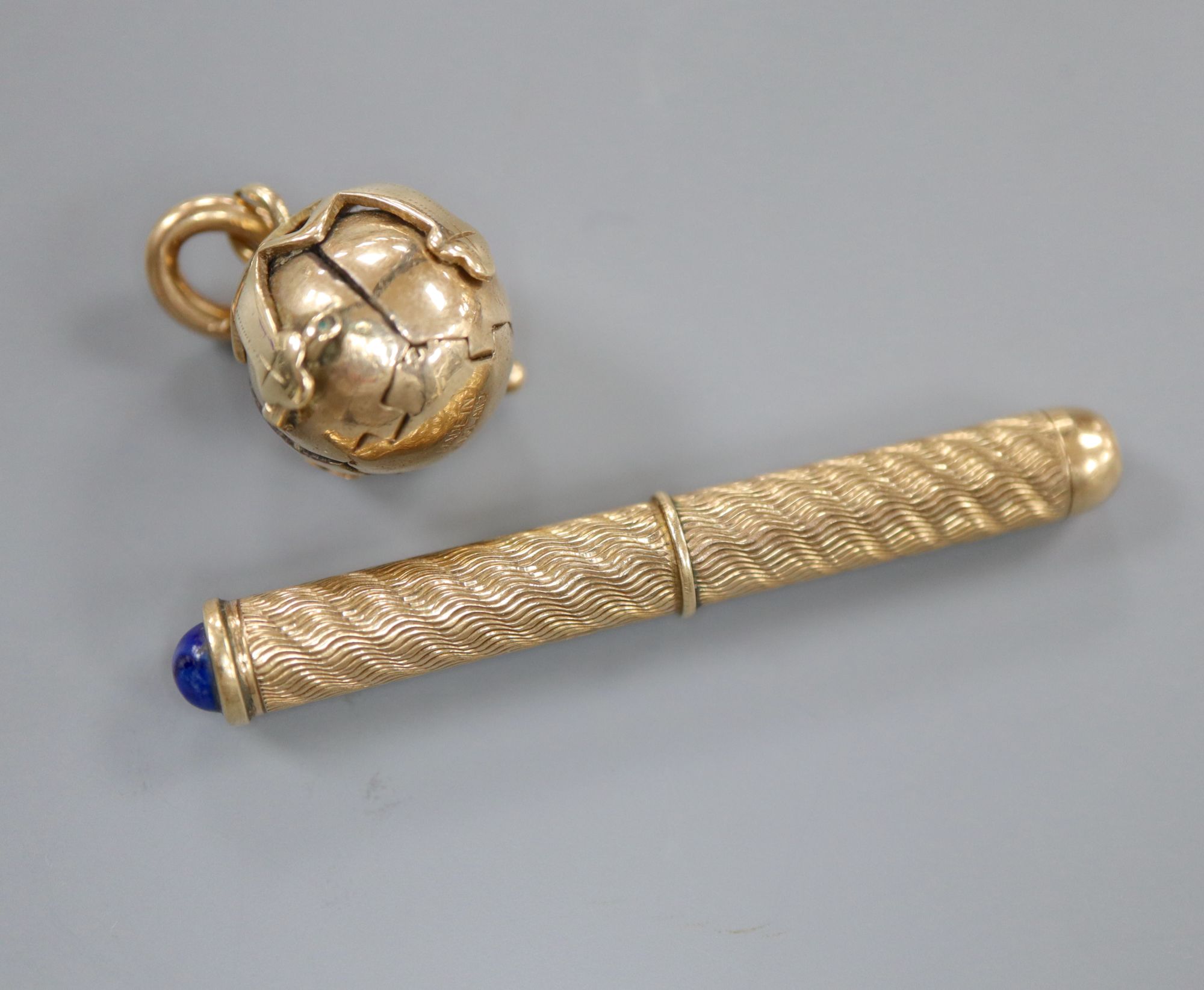 An engine turned 9ct. gold toothpick, with lapis lazuli cabochon, 49mm and a 9ct. overlaid masonic ball pendant,
